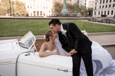 bride in a vintage Porsche convertible with groom kissing her forehead