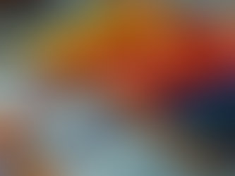 A row of colourful threads on wooden bobbins.