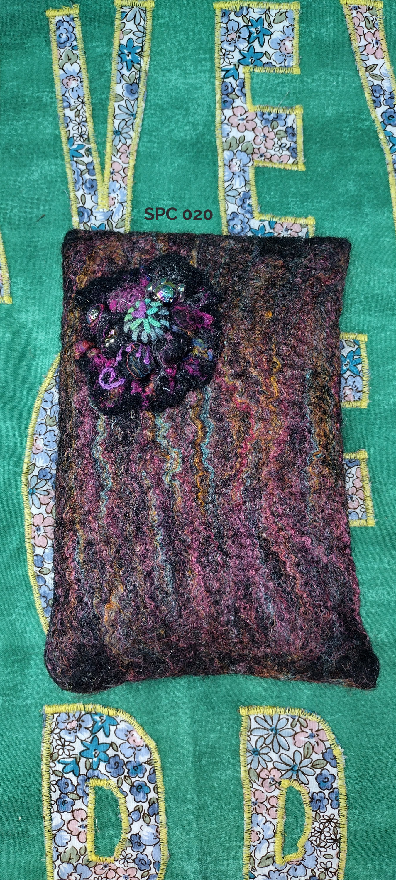 Shibori style cluster in black on a dark marbled wool felt pincushion