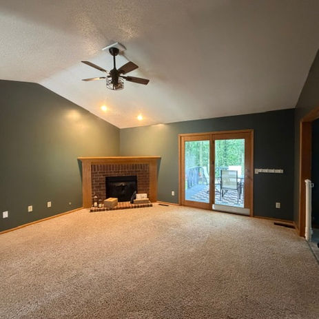 Interior painting of living room with green walls and fireplace