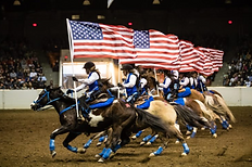 horses running in the rodeo with American flags