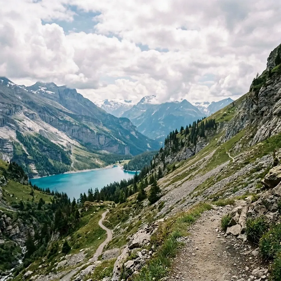Landscape photography of a vibrant turquoise lake set within dramatic mountain scenery. A winding hiking trail leads towards the water, evoking a sense of adventure.