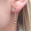Thumbnail: Three silver, rose gold and metallic small heart earrings in model's ear
