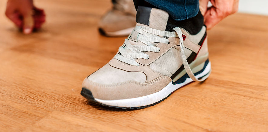 A man puts on sneakers and ties his shoelaces_edited.jpg