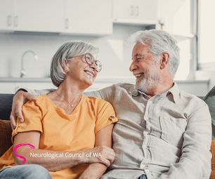 Middle-aged woman and man sit together, smiling at each other with eye contact