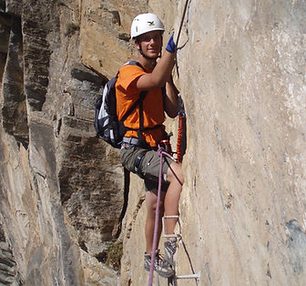 alpinista escalando la via ferrata del roc del quer en andorra con un guia de montaña