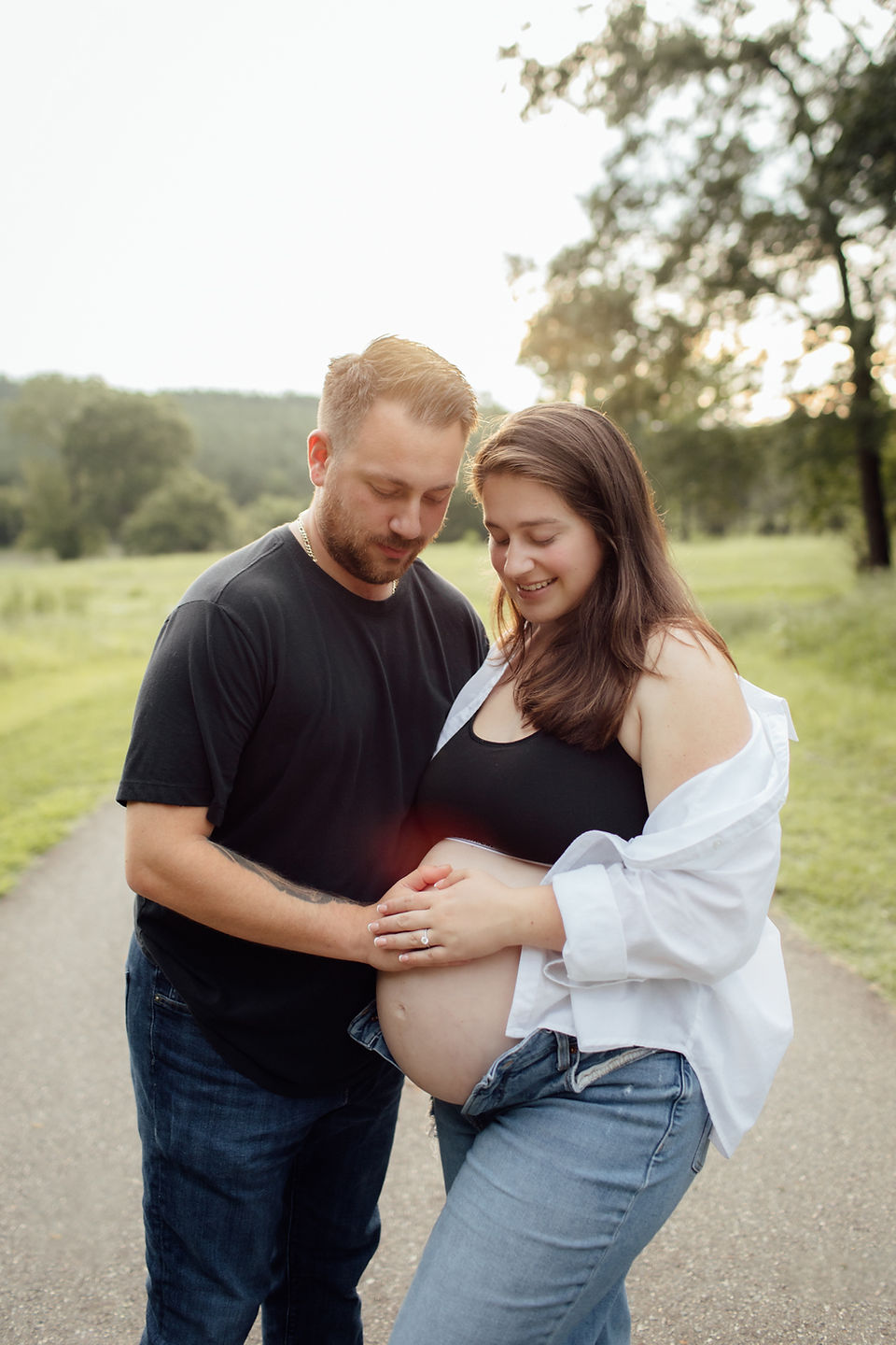 A man and wife touching her pregnant belly during their Charlotte maternity photography session