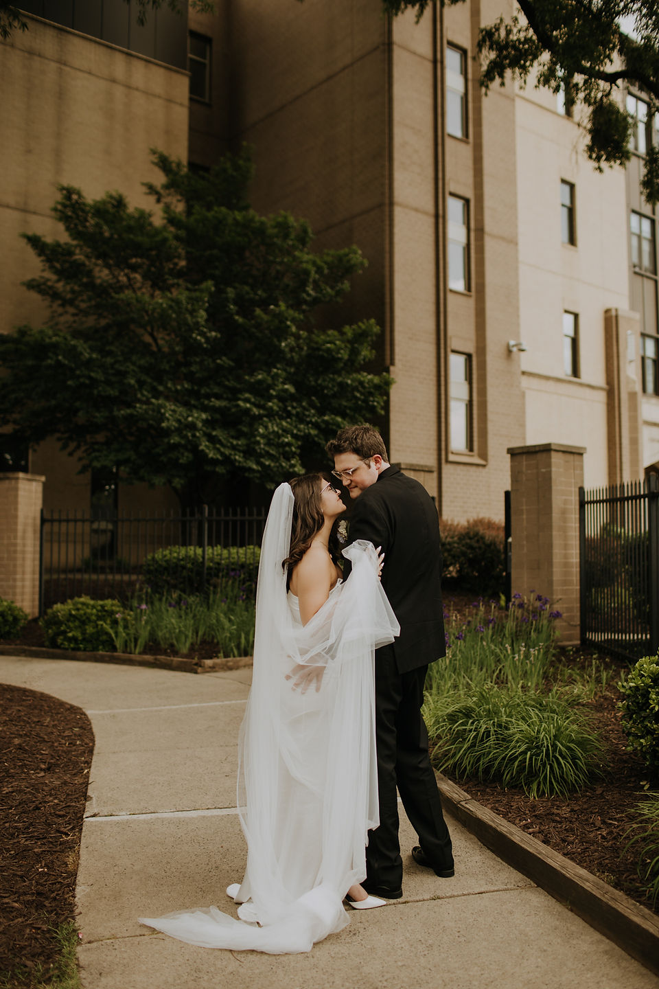 A bride and groom on a Charlotte NC street looking lovingly at each other