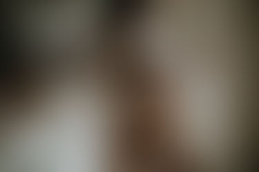 a pregnant woman with her hand on her belly in a bra and robe for her charlotte maternity session
