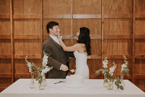 a bride pushing cake into her groom's face on their Cornelius micro wedding day