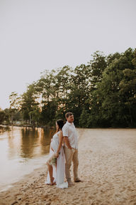 man and woman on beach standing back to back for their Charlotte maternity shoot