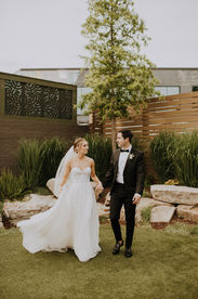 A bride and groom walking together smiling at each other for their NC wedding photographer
