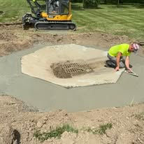 Worker finishing concrete around a drain