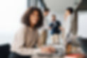 Attractive african young confident businesswoman sitting at the office table with group of