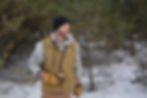 Man holding flask and axe in the snow