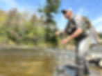 Fly angler fishing in a river on a sunny day