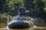 Young man casting a fly rod from the front of Outcast Drifter 13 fishing raft
