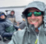 Three men in a fishing boat in the rain