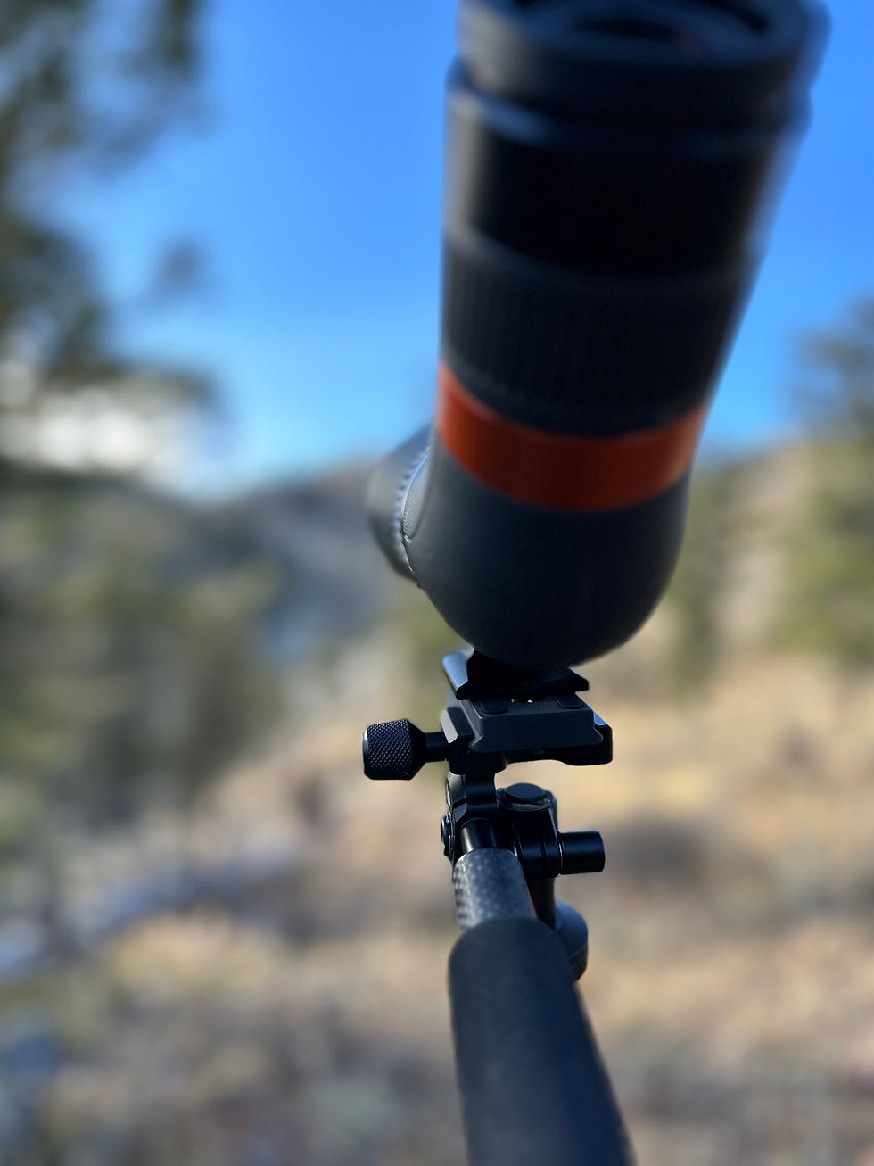 close up of a spotting scope and tripod in the mountains