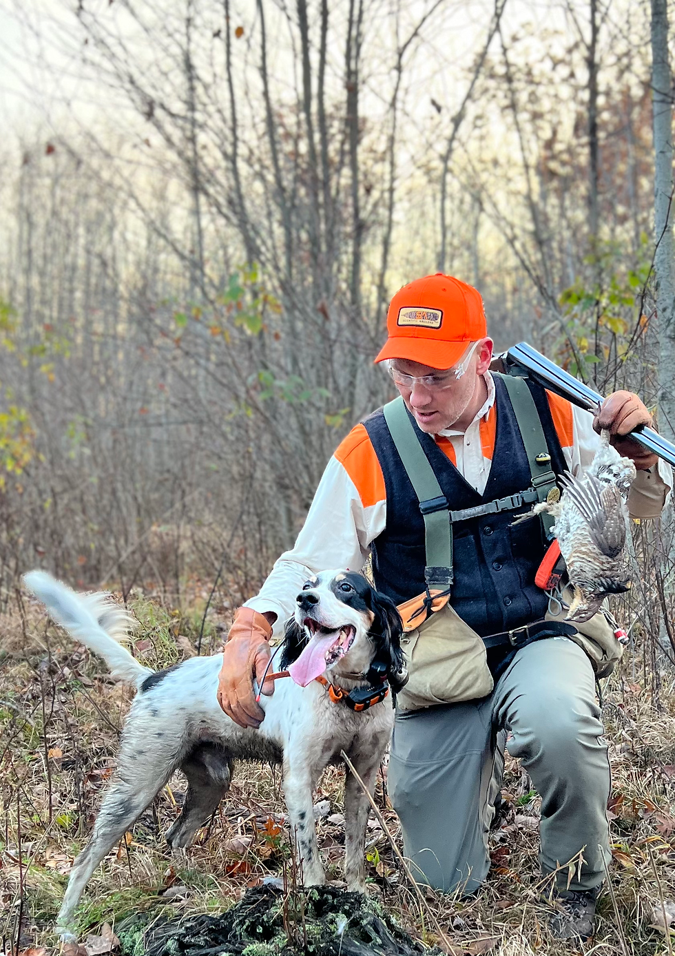 hunter posing with shotgun, bird dog and ruffed grouse