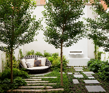 A stone water feature in the back of a lovely minimal is garden.