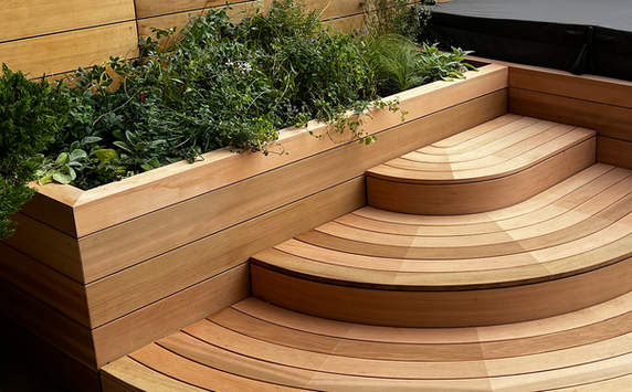 A cedar clad planter connected to cedar hot tub stairs.