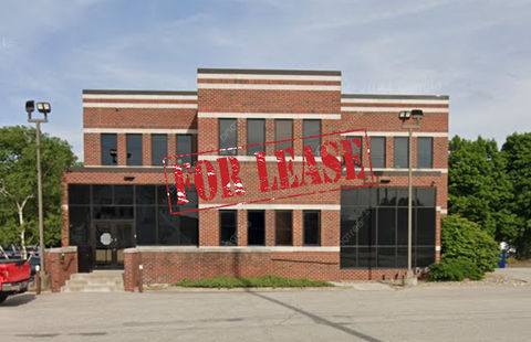A large brick building with a for lease stamp on it