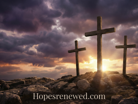 Three wooden crosses on rocky terrain at sunrise, with dramatic clouds. Text: Hopesrenewed.com. The scene conveys a sense of hope.