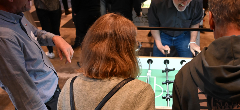 Gruppe spielt an Green Heron Tischkicker, Menschen lachen