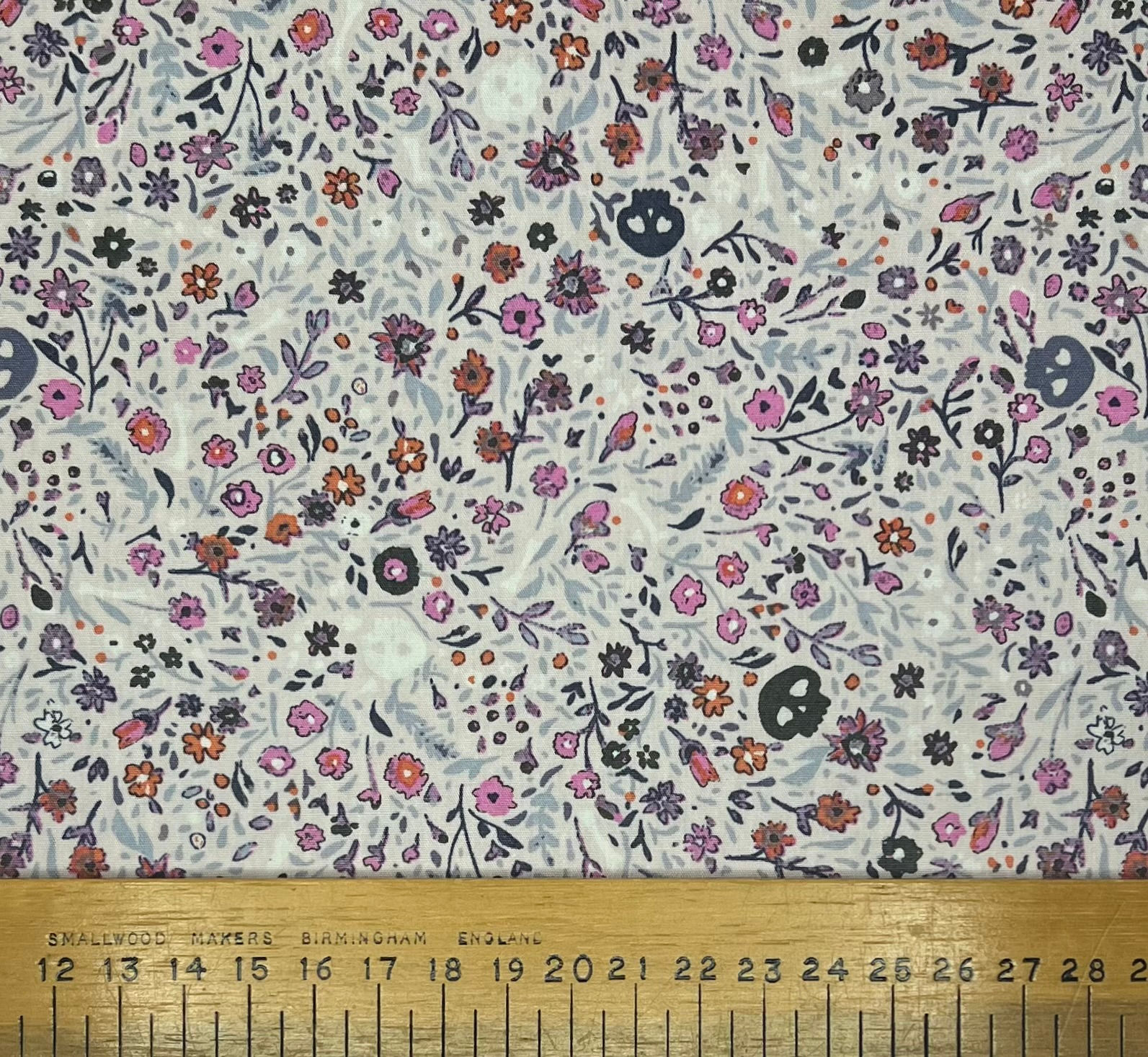 Flowers and skulls on a violet cotton background