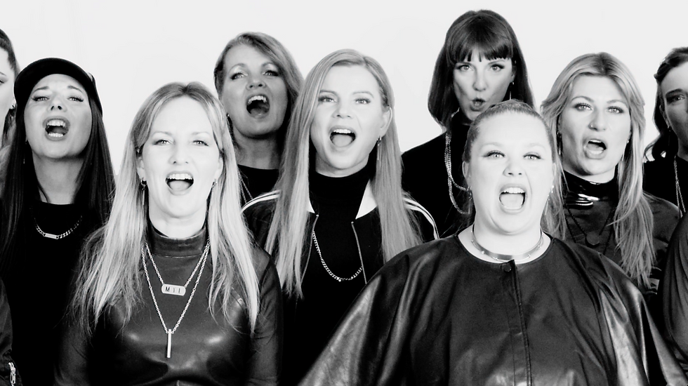 Kraftvolle Chorperformance in Schwarz-Weiß – eine Gruppe von Sängerinnen strahlt Energie, Zusammenhalt und moderne Stärke aus.