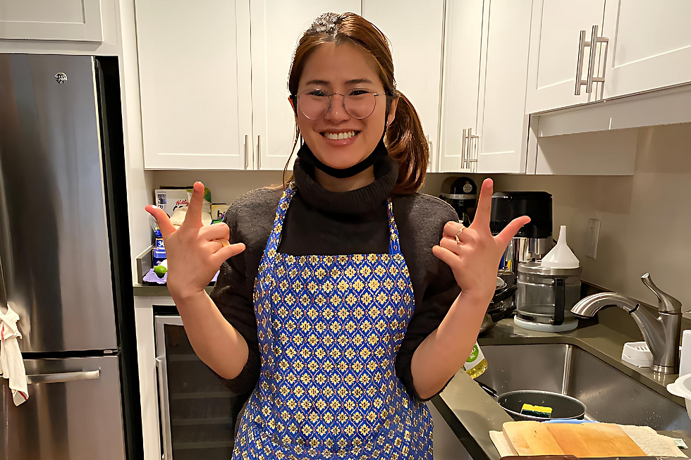 Rasa, founder of Smile Café, smiling in the kitchen while cooking and preparing food.