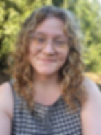 Rebecca Massek smiling in front of a green natural background