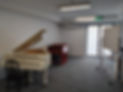 a room with a piano, harpsichord and whiteboard