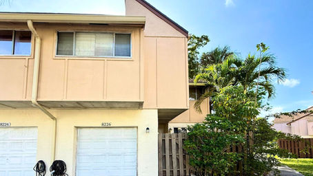 Front view of 3-bedroom townhome at 8226 NW 8th Pl Unit 6 Plantation FL with private garage and tropical landscaping