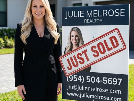 Real estate agent Julie Melrose standing by a "Just Sold" yard sign with contact info (954) 504-5697 and website in front of a house.