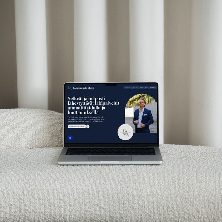 Kannettava sohvalla, jossa auki Lakitoimisto aLexi Oy:n nettisivut.