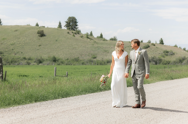 Wedding couple walking the road at 1889 barn in Bozeman Montana.png