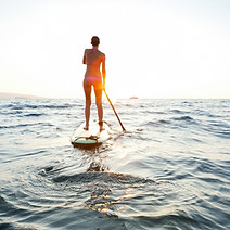 Fille sur SUP au coucher du soleil
