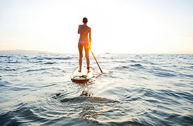 Fille sur SUP au coucher du soleil