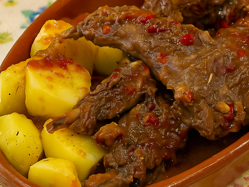 Tacho de coelho à caçador com molho espesso, batatinhas e ervas aromáticas
