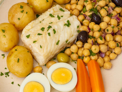 Prato de bacalhau com batata cozida, grão-de-bico, cenoura, ovo e cebola roxa, servido com azeite e vinagre
