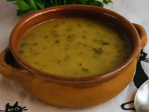 Tigela de sopa de salsa cremosa com pedaços de legumes e salsa fresca