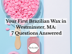 Pink hard wax beads, a wooden spatula, and a skincare bottle for a first Brazilian wax at Flutter Yen Aesthetics in Westminster, MA