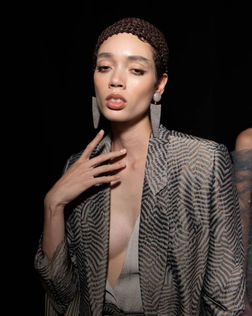 Close-up of a model in a tailored gray blazer from Giorgio Armani's collection, showcasing a polished nude manicure by Sofie Roth
