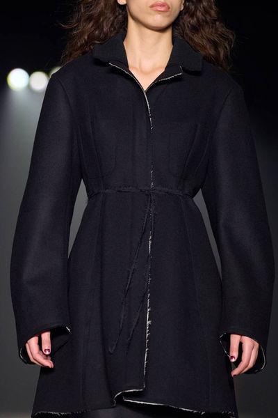 Model in a black coat with subtle embellishments from Jason Wu's collection, complemented by an elegant nude manicure by Sofie Roth
