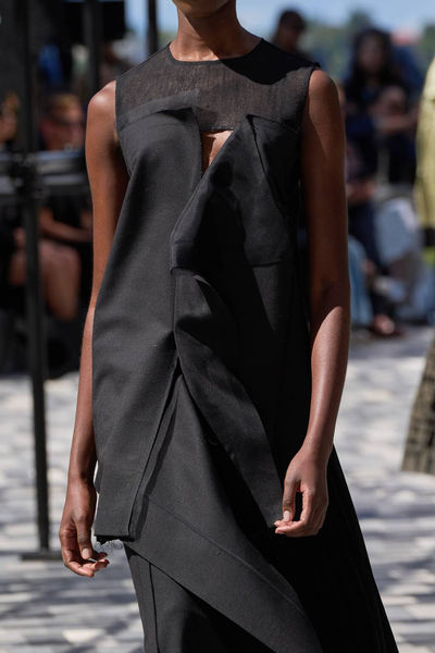 Close-up of a black textured gown with structured details from Jason Wu's collection, featuring a refined nude manicure by Sofie Roth
