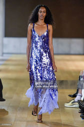 Model in a sequined blue dress with lavender fringe detailing from Monse's collection, featuring a clean nude manicure by Sofie Roth
