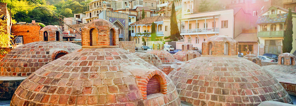 Купола серных бань в историческом районе Абанотубани в Тбилиси, окружённые традиционной грузинской архитектурой и узкими улочками