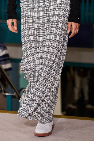 Model in a plaid coat with wide-leg trousers from Tommy Hilfiger's collection, styled with a flawless nude manicure by Sofie Roth
